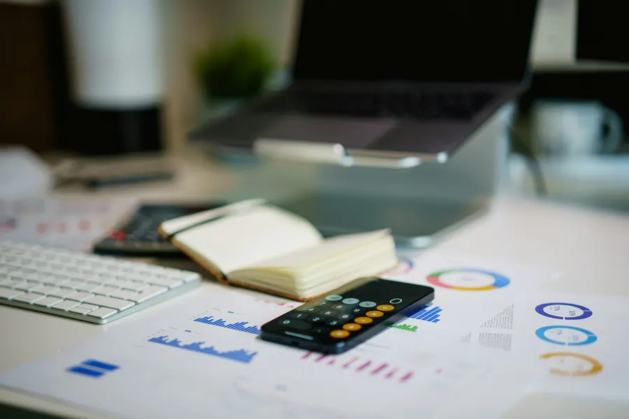 Un bureau avec une calculatrice et des graphiques financiers
