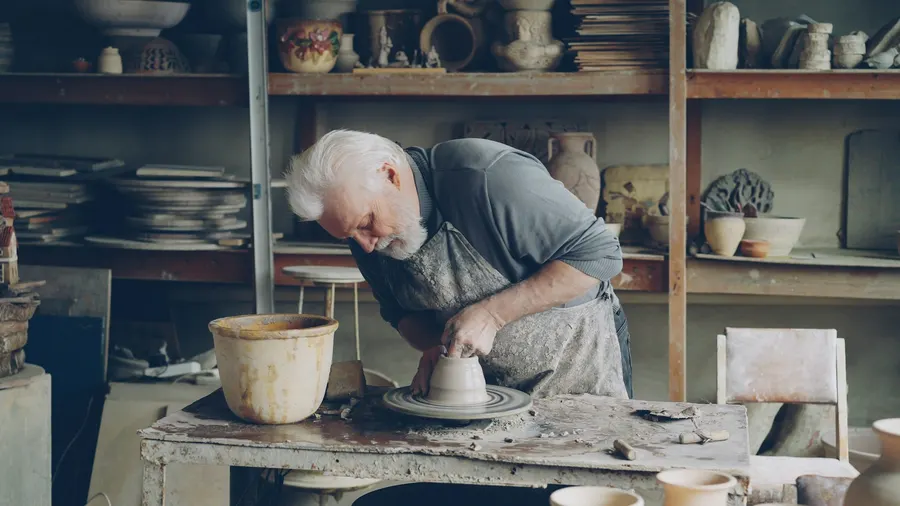 Un potier âgé au travail dans son atelier